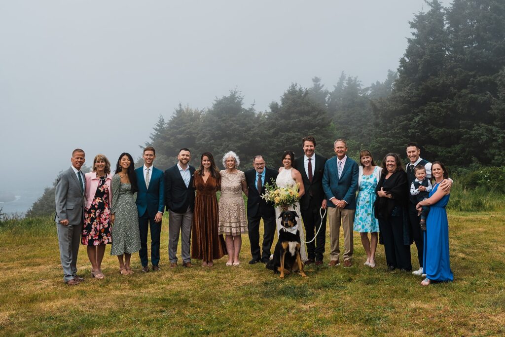 Bride and Groom pose for a family photo with loved ones during their Oregon Coast elopement