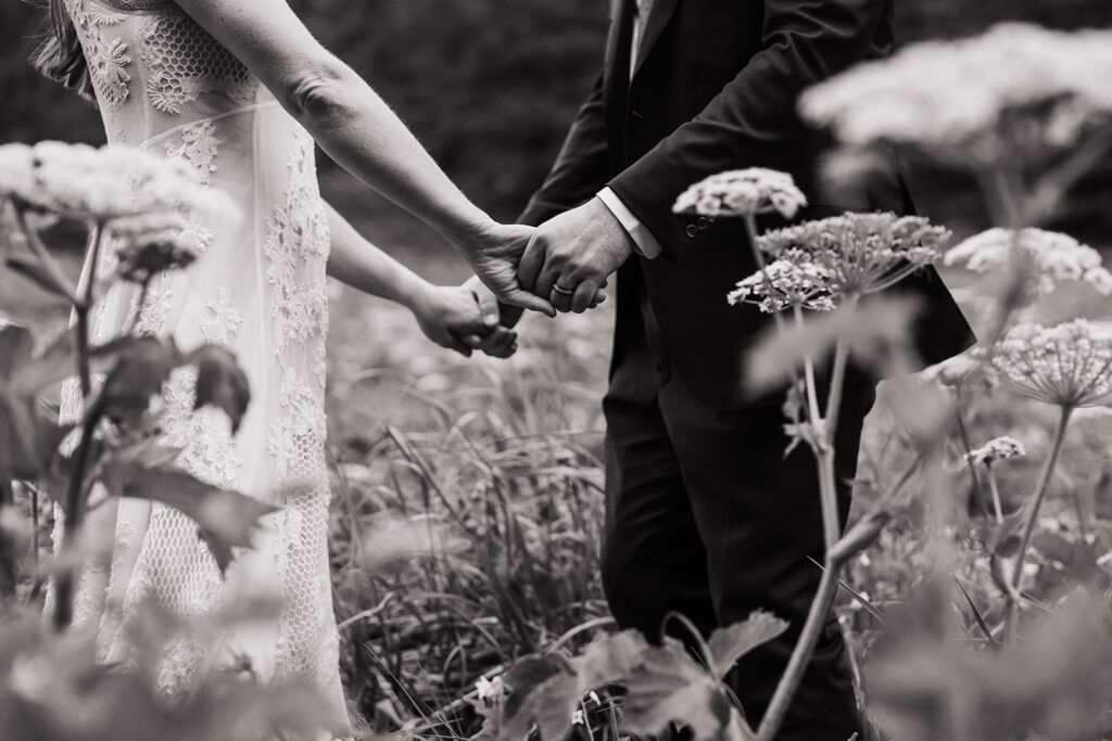 Bride and groom hold hands in a field on the Oregon Coast 