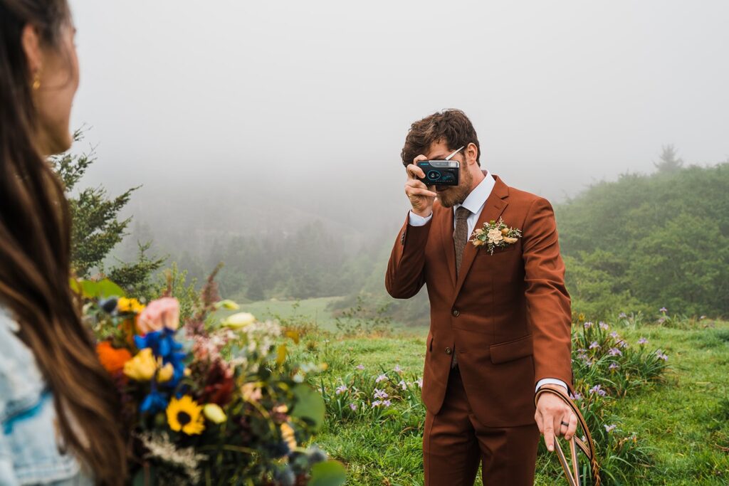 Groom snapping a polaroid photo of a bride after their first look on the Oregon Coast