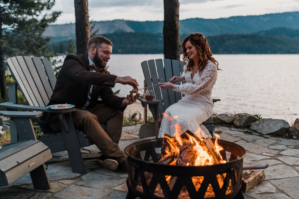 Bride and groom cook s'mores over a fire pit during their elopement in the PNW