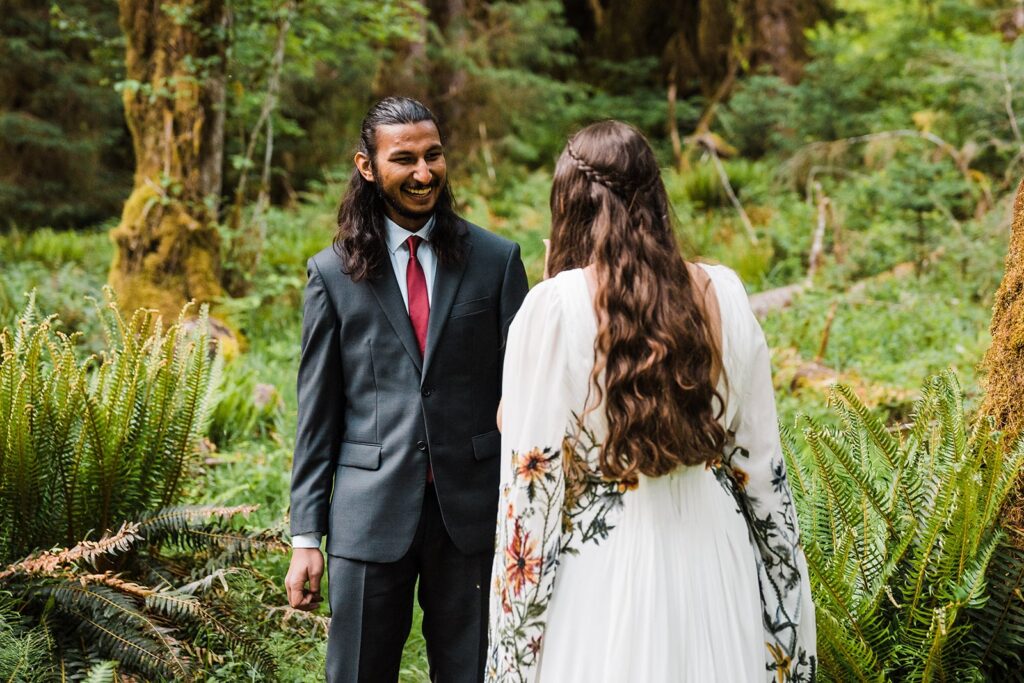 Groom smiles during wedding first look in Hoh Rainforest