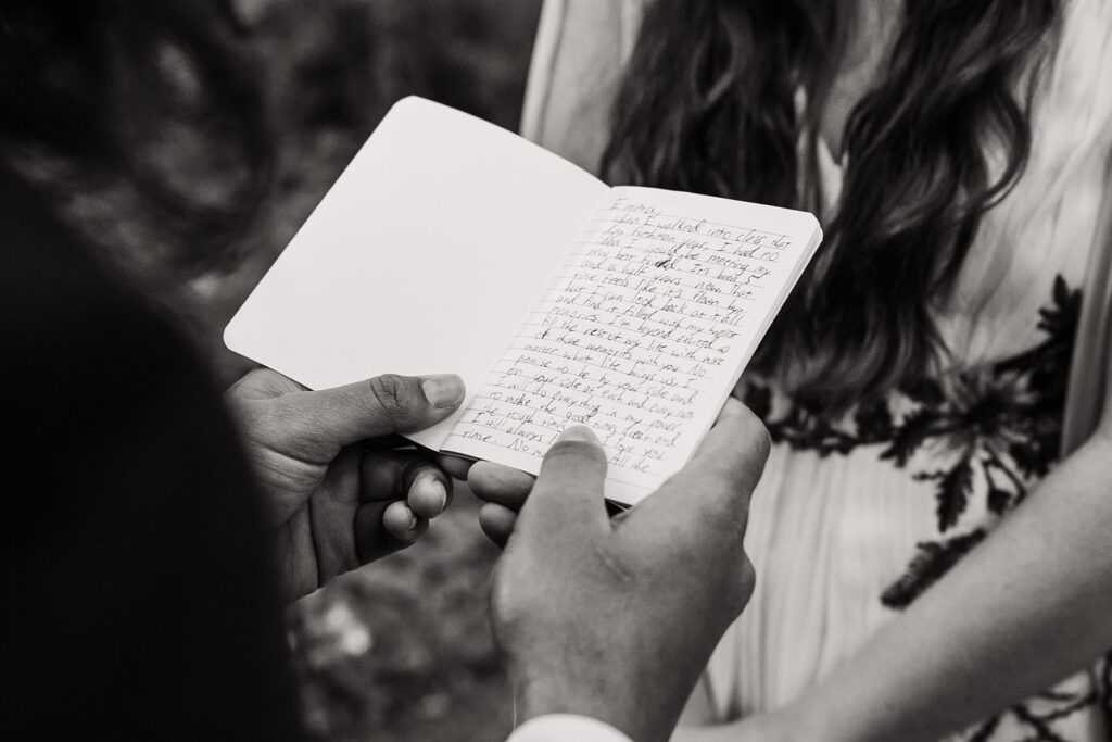 Groom holds vow book with handwritten vows