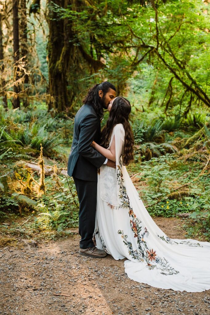 Bride and groom kiss during Hoh Rainforest wedding ceremony in Olympic National Park