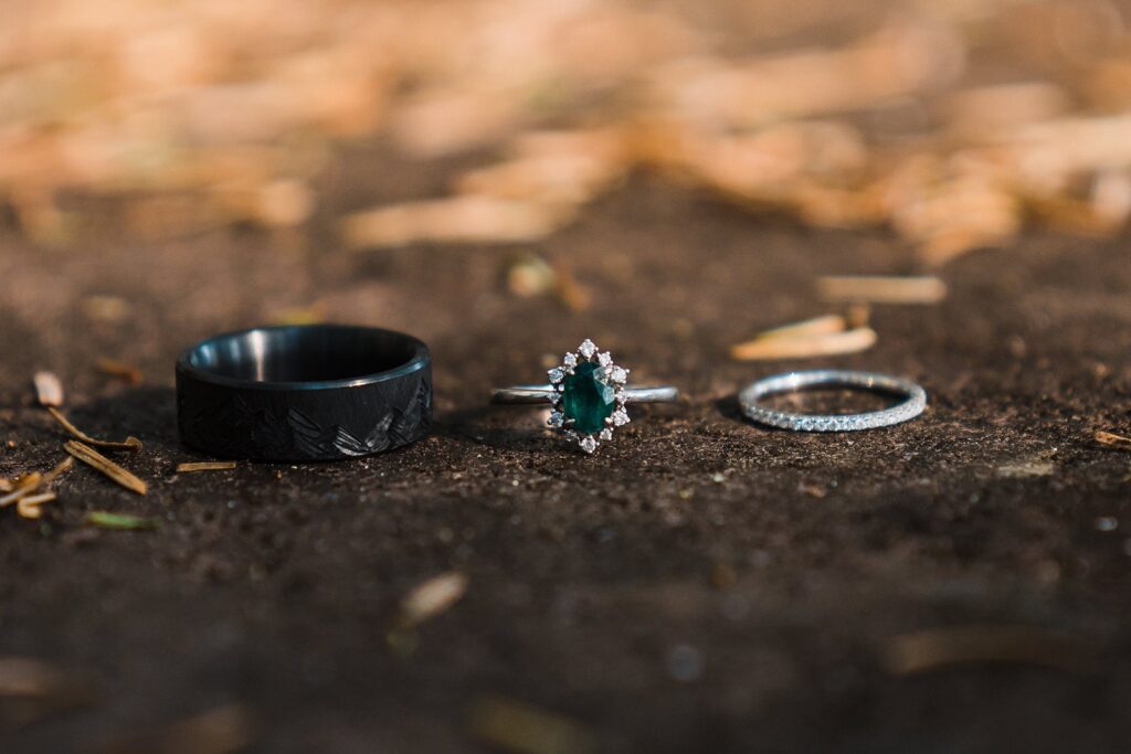 Bride and groom's black, emerald, and diamond, wedding bands