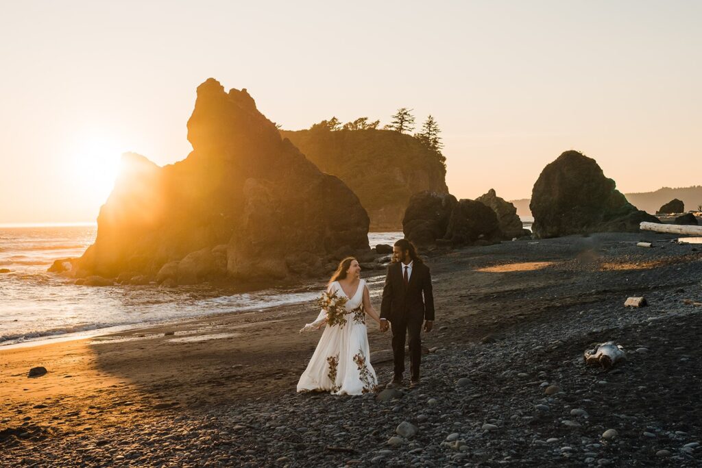 Bride and groom hold hands while running across Ruby Beach after their Hoh Rainforest wedding
