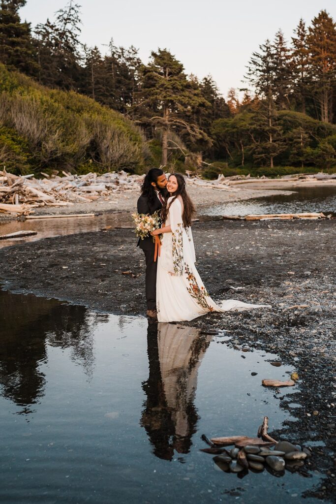 Groom kisses bride during their Hoh Rainforest wedding photos on Ruby Beach