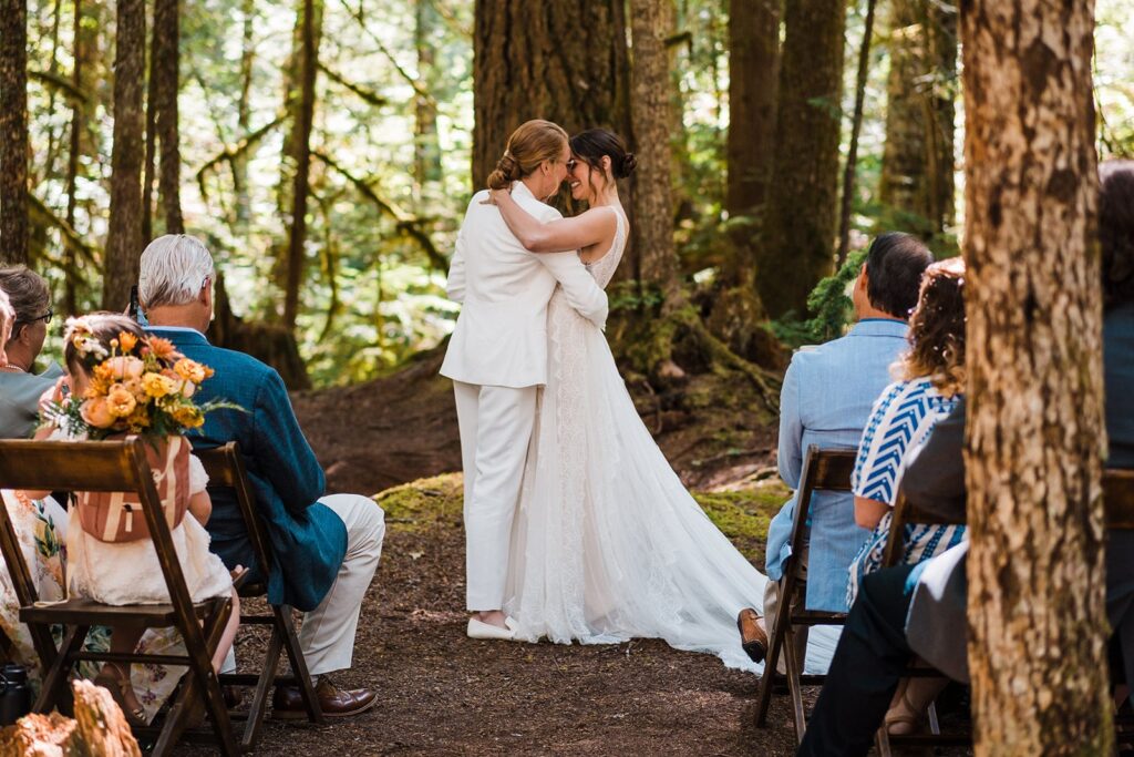 Brides kiss at Olympic National Park wedding ceremony