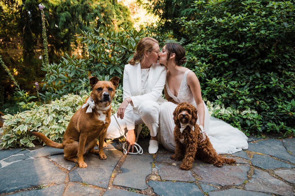 Bride kiss while taking a photo with their two pups at Olympic National Park wedding