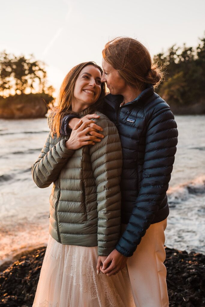 Brides wear Patagonia jackets during their beach wedding photos in Olympic National Park