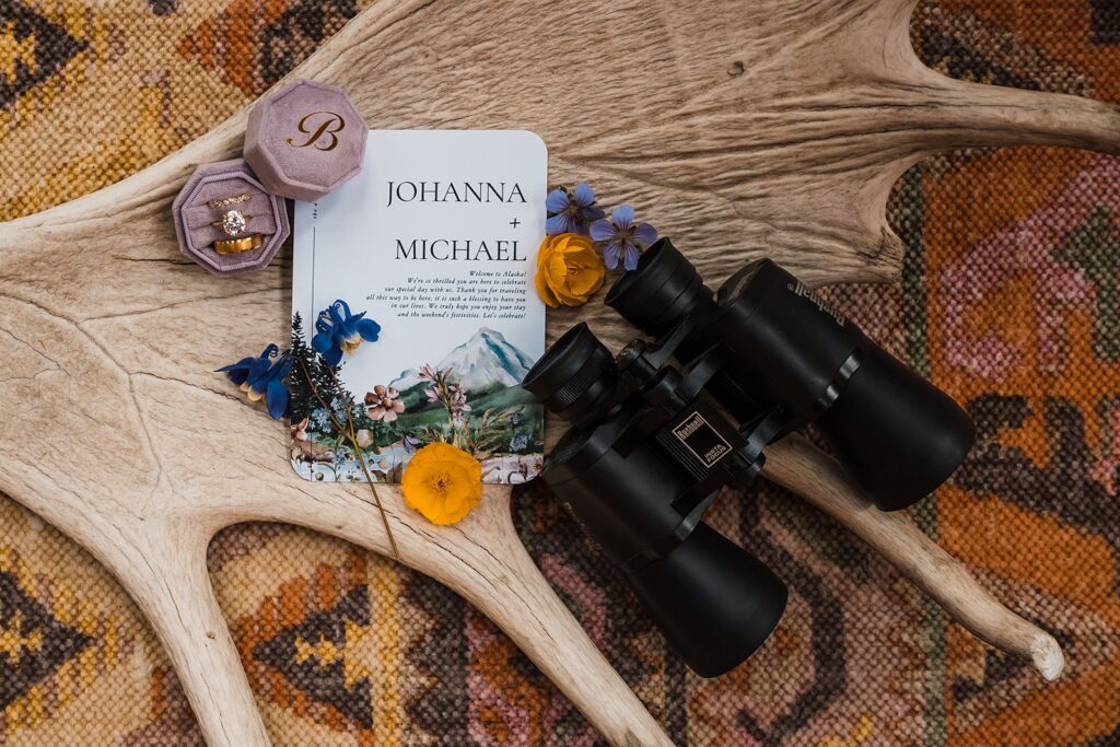 Purple, yellow, and blue elopement details with black binoculars