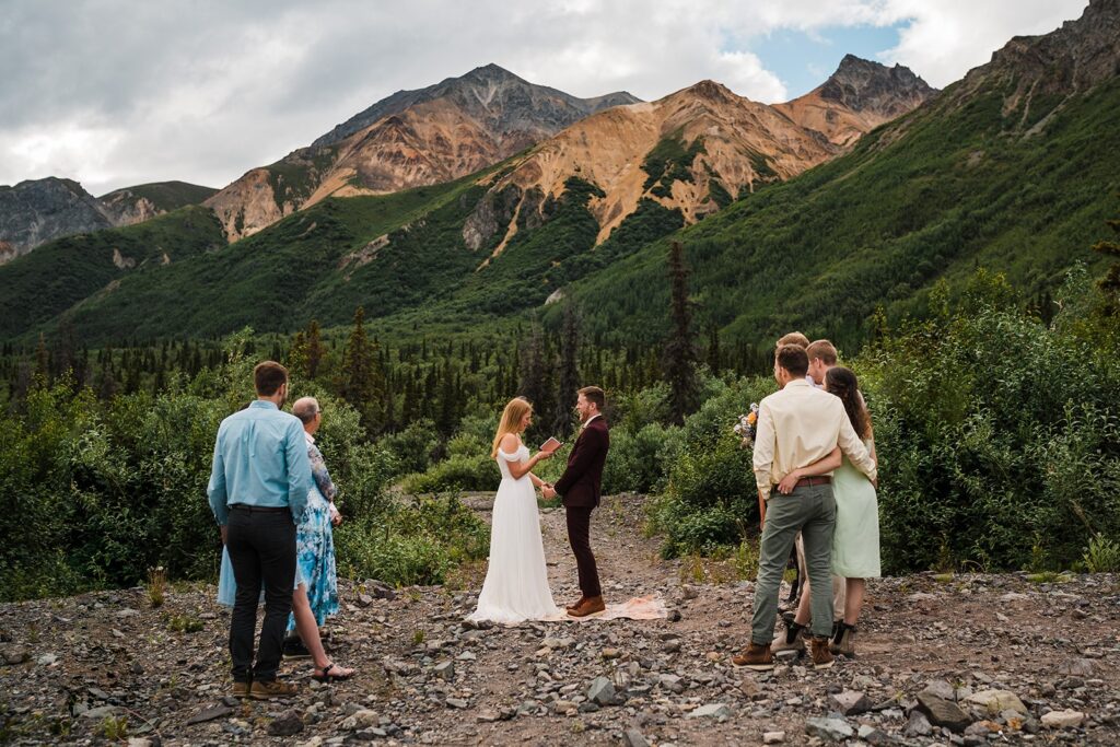Bride and groom elope in Alaska with family and friends watching nearby