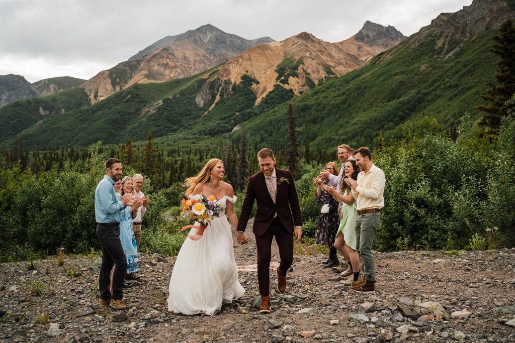 Bride and groom laugh during their elopement ceremony exit in the mountains