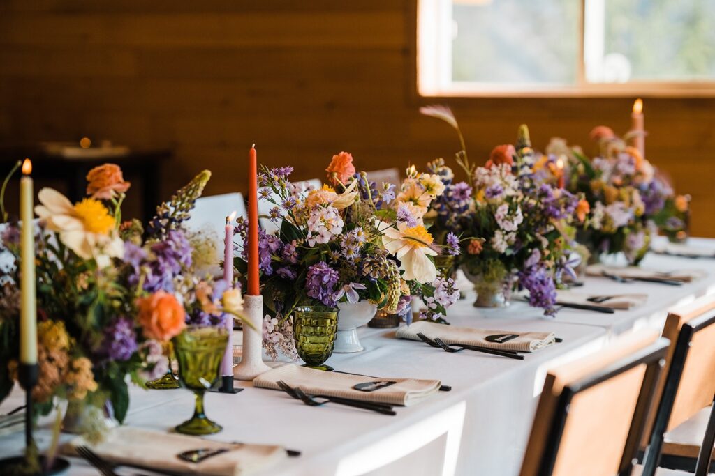 White reception table with colorful wildflowers running down the center