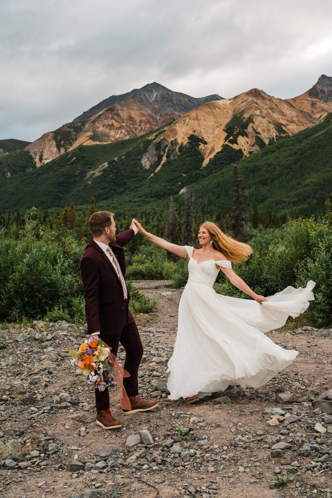 Groom twirls bride around during outdoor elopement in Alaska