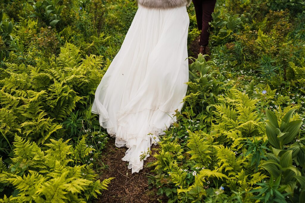 Bride and groom walking through lush green trail at Hatcher Pass elopement