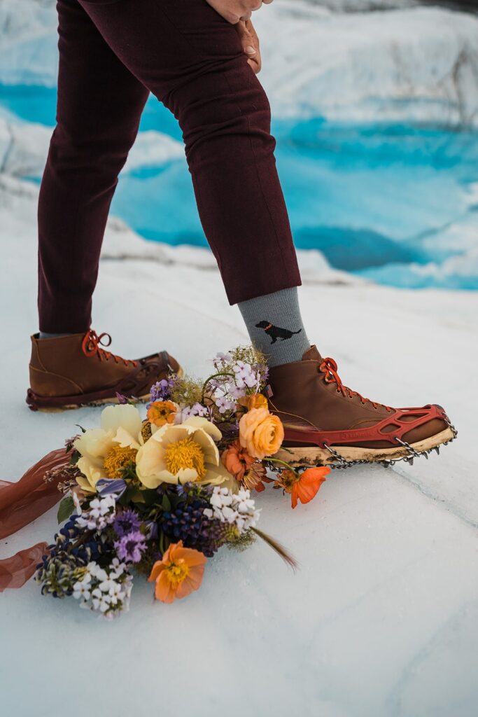 Groom wearing hiking boots and custom dog socks during Alaska helicopter elopement 