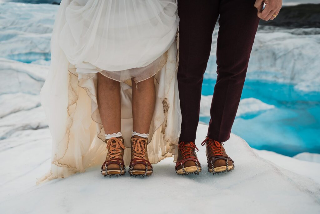 Bride and groom wear hiking boots during their helicopter elopement on an Alaskan glacier