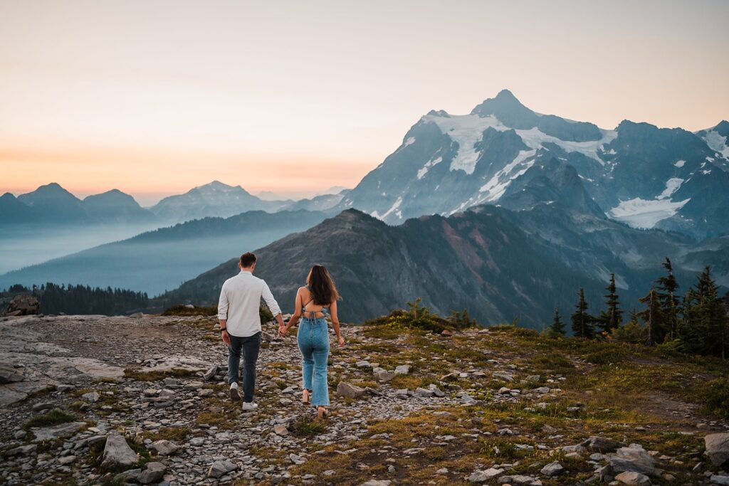Bride and groom hold hands while walking on a hiking trail at Artist Point during their sunrise elopement photos