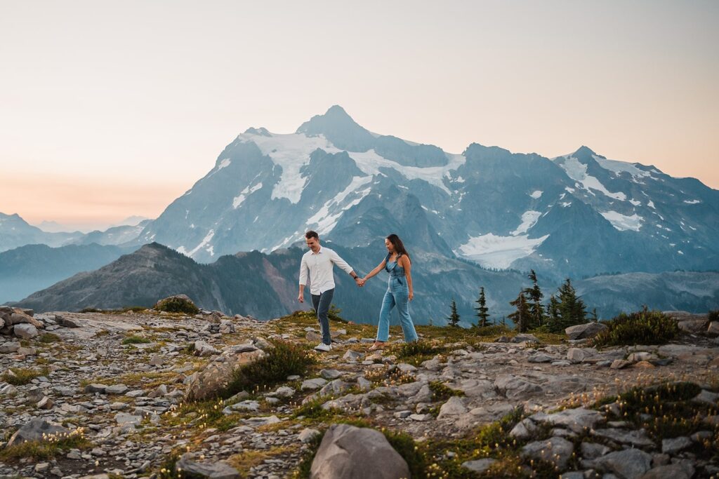 Bride and groom hold hands while walking along a hiking trail at Artist Point during their sunrise elopement photos