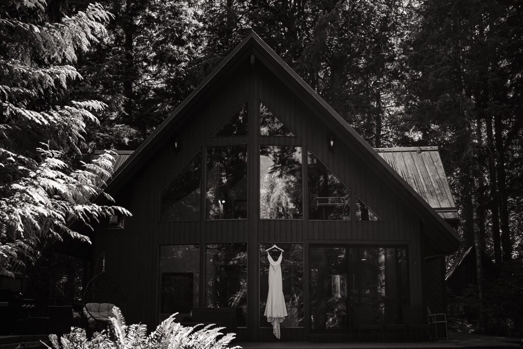 White wedding dress hanging from Airbnb cabin windows at Artist Point elopement