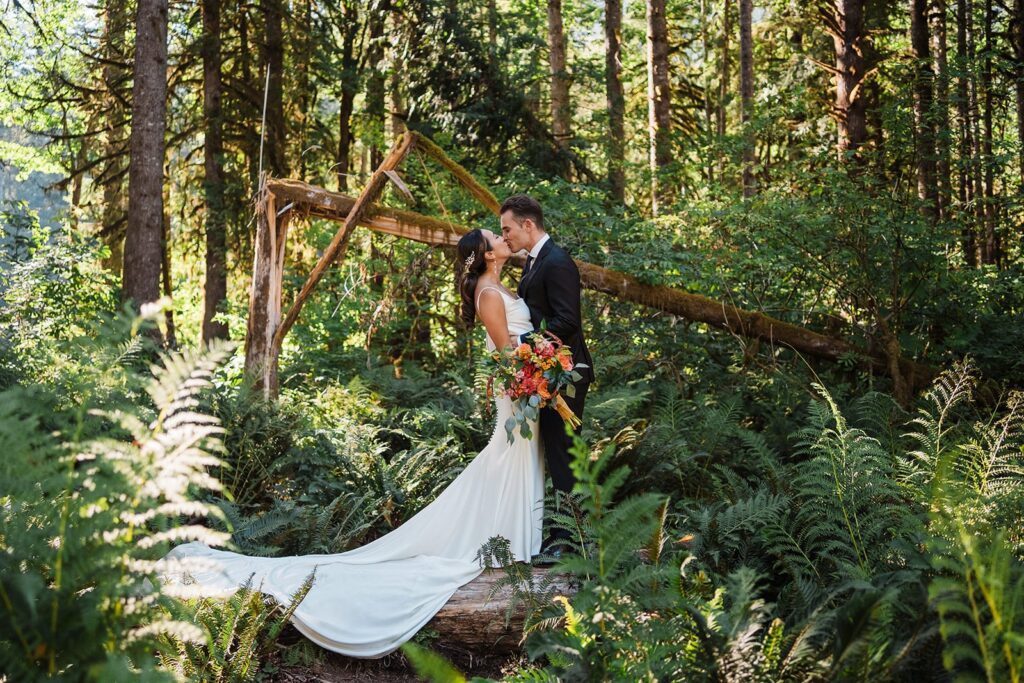 Bride and groom kiss in the forest during their North Cascades elopement