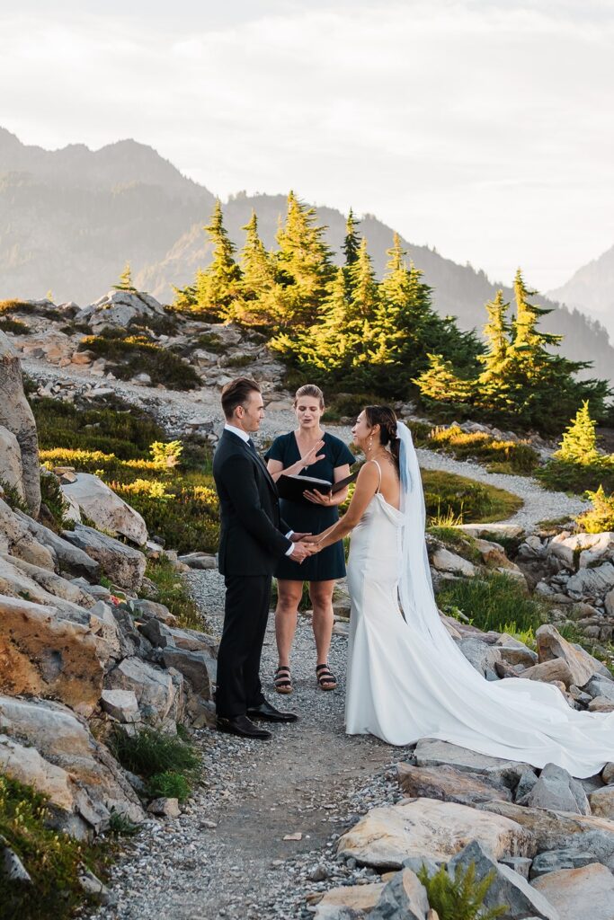 Bride and groom stand on a hiking trail and exchange vows at their Artist Point elopement