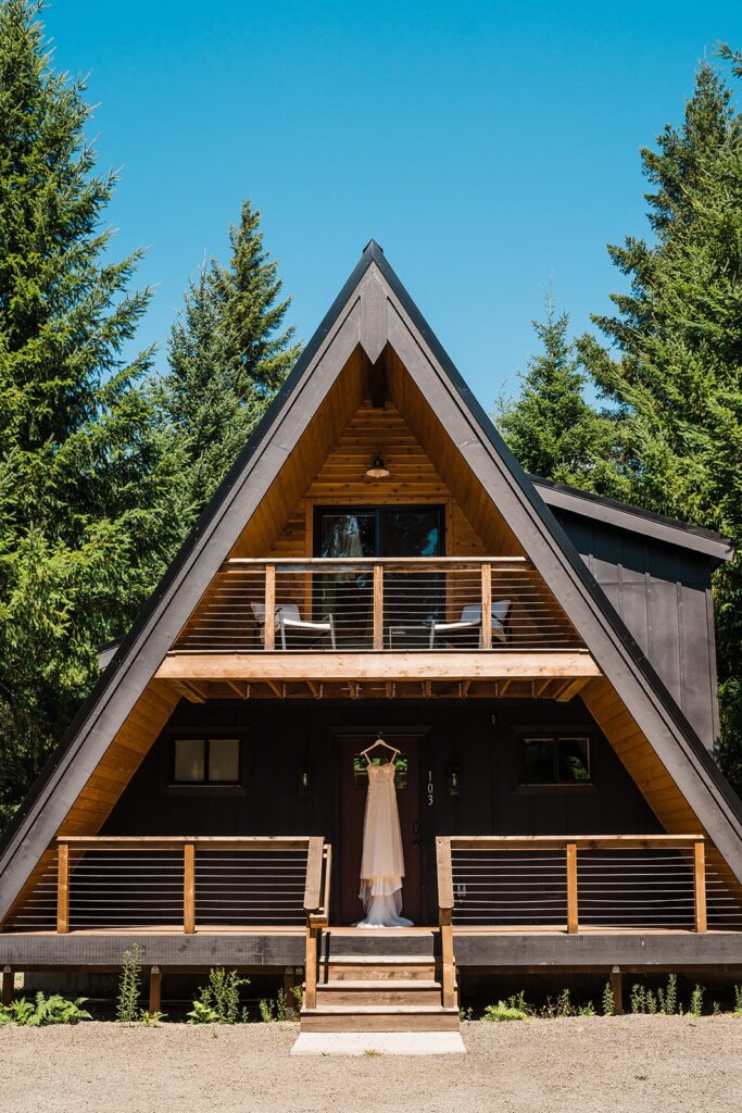 White wedding dress handing from the ceiling of A-Frame cabin in Packwood, Washington