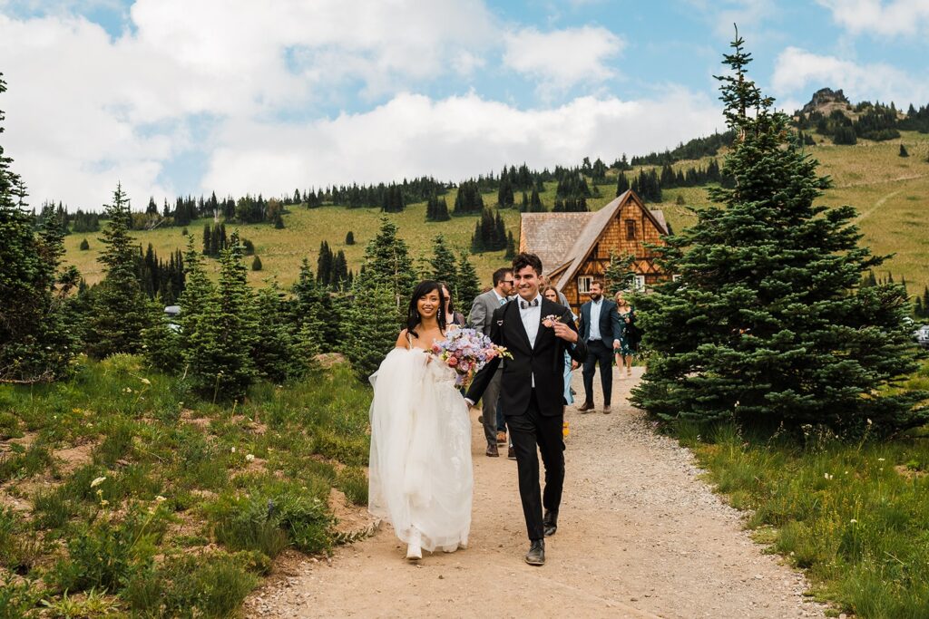 Bride and groom walk toward their Mount Rainier wedding ceremony spot at Sunrise Visitor Center