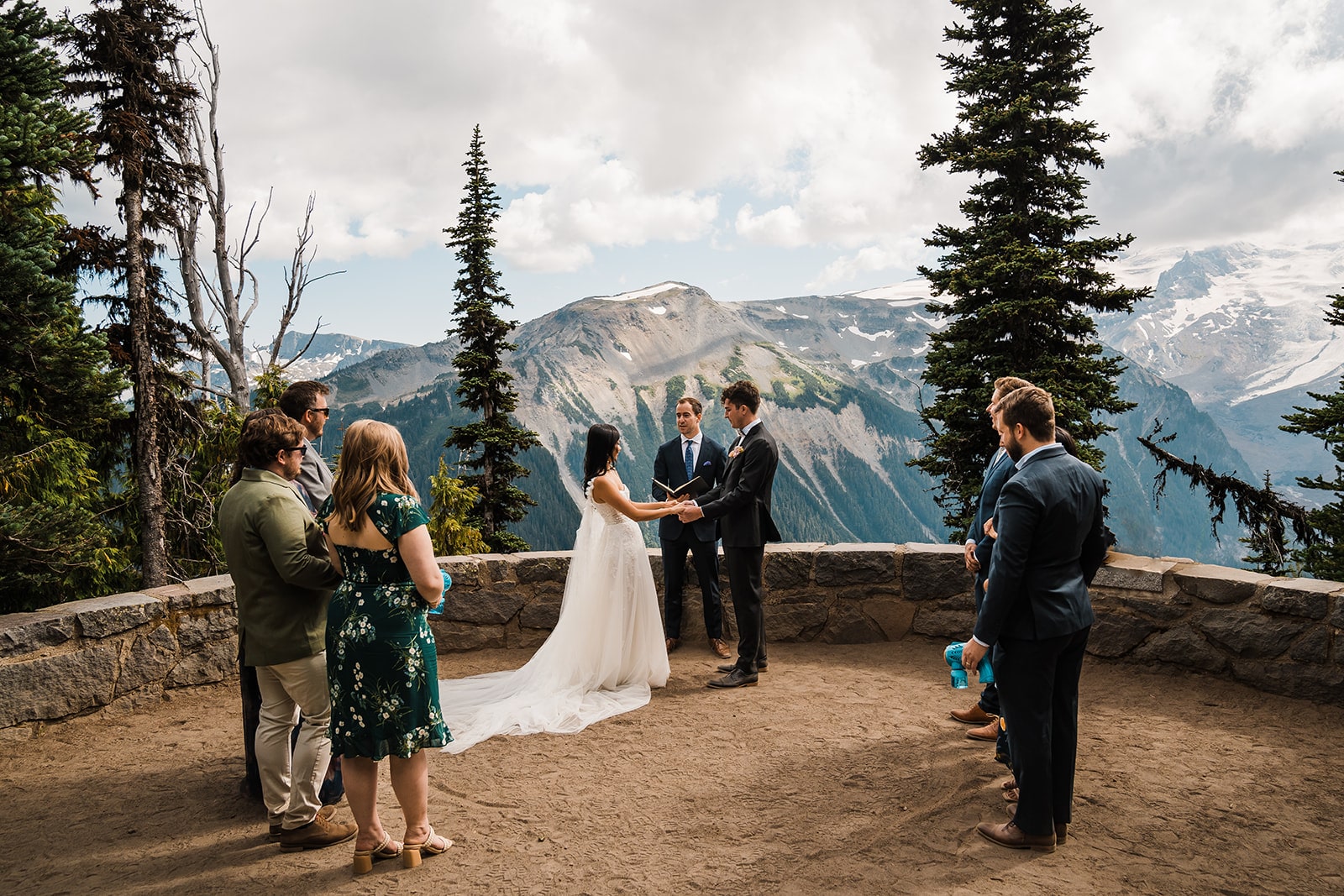 Bride and groom hold hands at a mountain overlook at their Washington state park wedding venue.