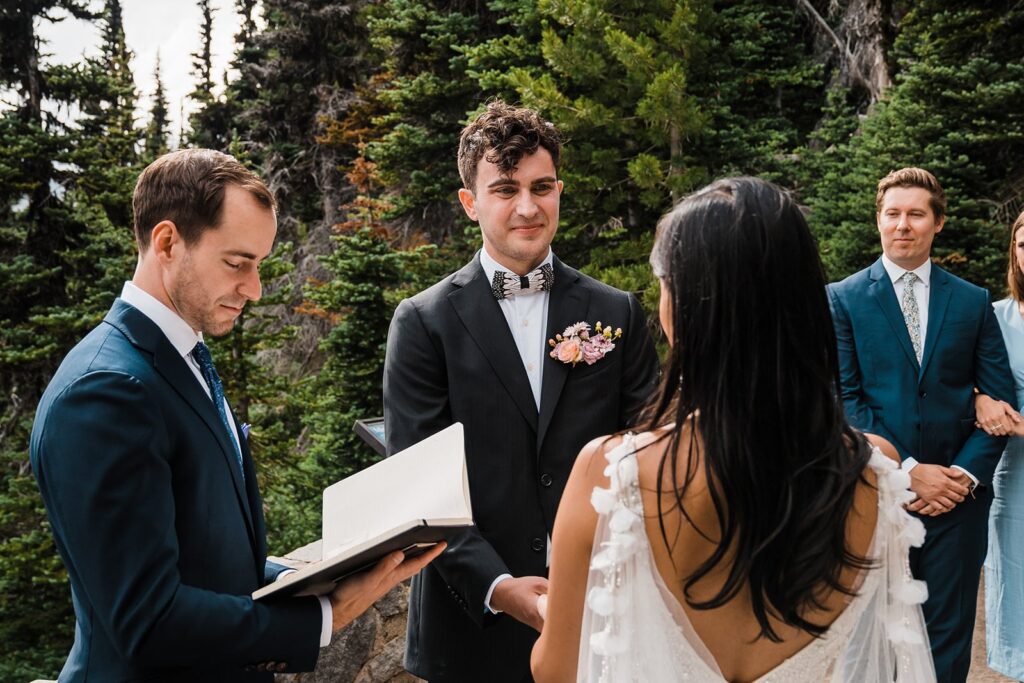 Groom smiles at bride during their Mount Rainier wedding ceremony