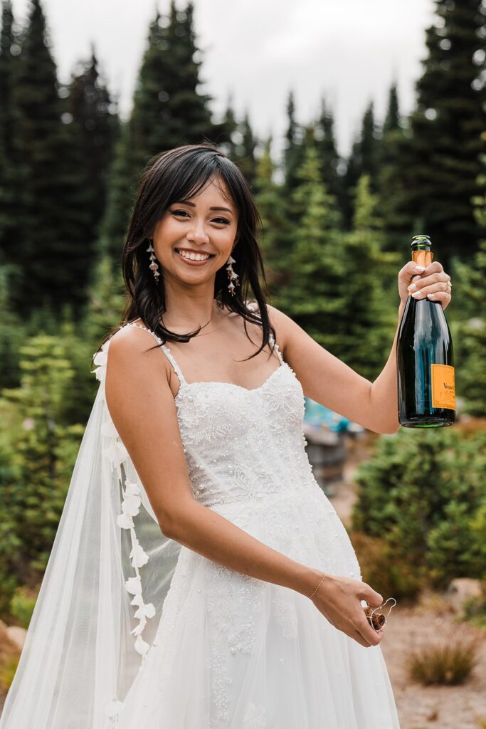 Bride pops champagne during picnic celebratory meal at Mount Rainier National Park