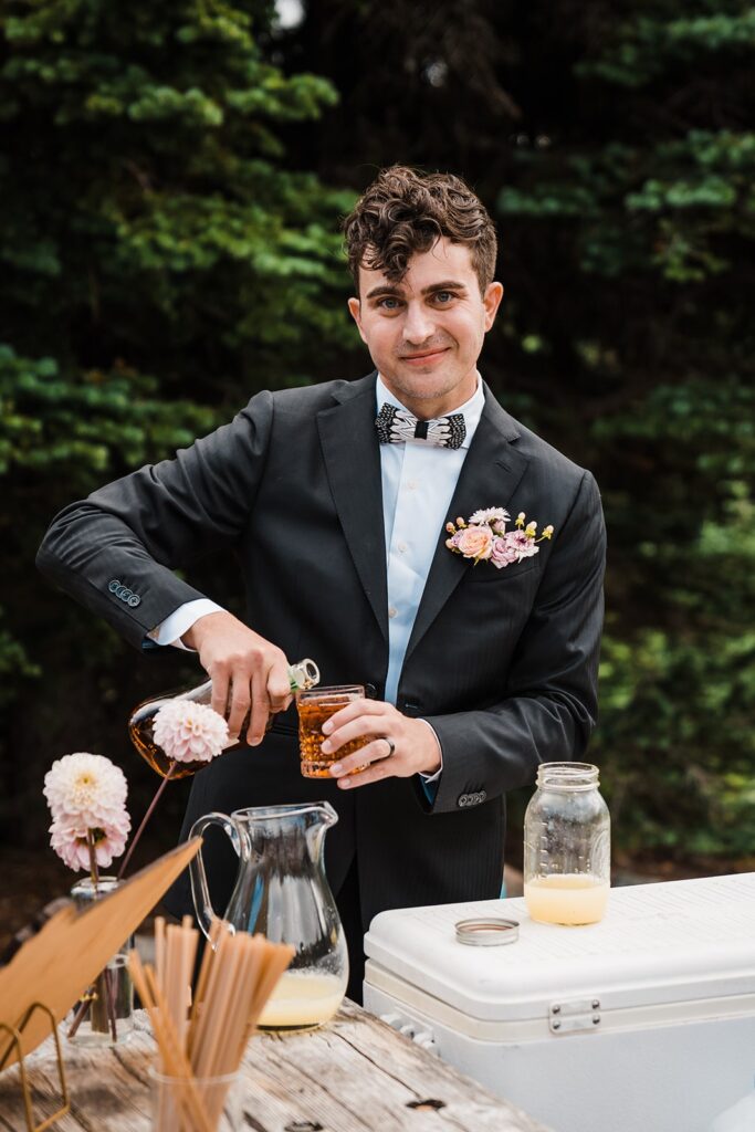 Groom pours alcohol at Mount Rainier National Park wedding celebratory meal