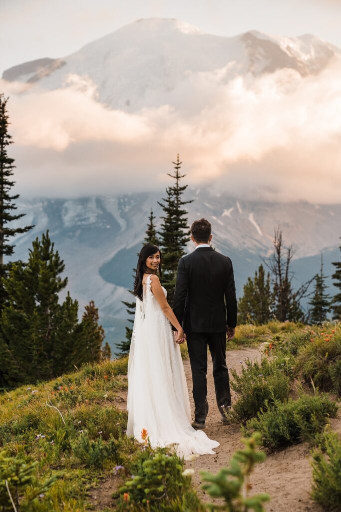 Bride and groom walk around a hiking trail during their Mount Rainier National Park wedding