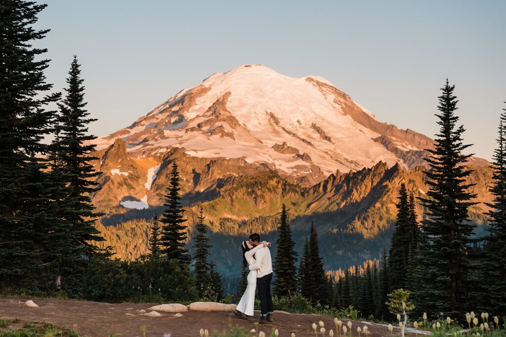 Bride and groom kiss during their sunrise elopement at an alpine lake in Washington