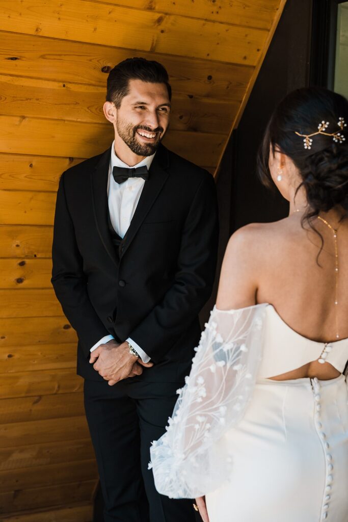 Groom smiles after turning around for wedding first look 