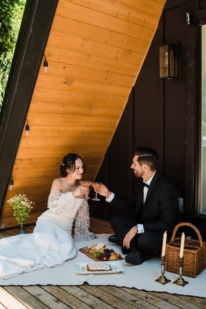Bride and groom share a picnic lunch at their Airbnb cabin in Washington