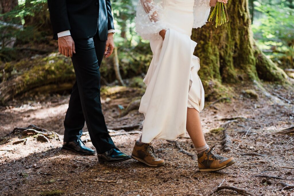 Bride and groom hike through a forest during their alpine lake elopement in Washington