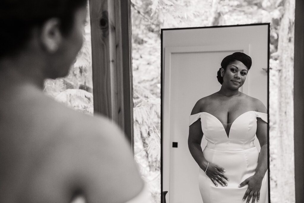 Bride looks at herself in the mirror after getting ready for her elopement in the North Cascades