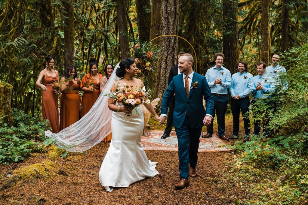 Bride and groom hold hands as they exit their family elopement ceremony in the North Cascades