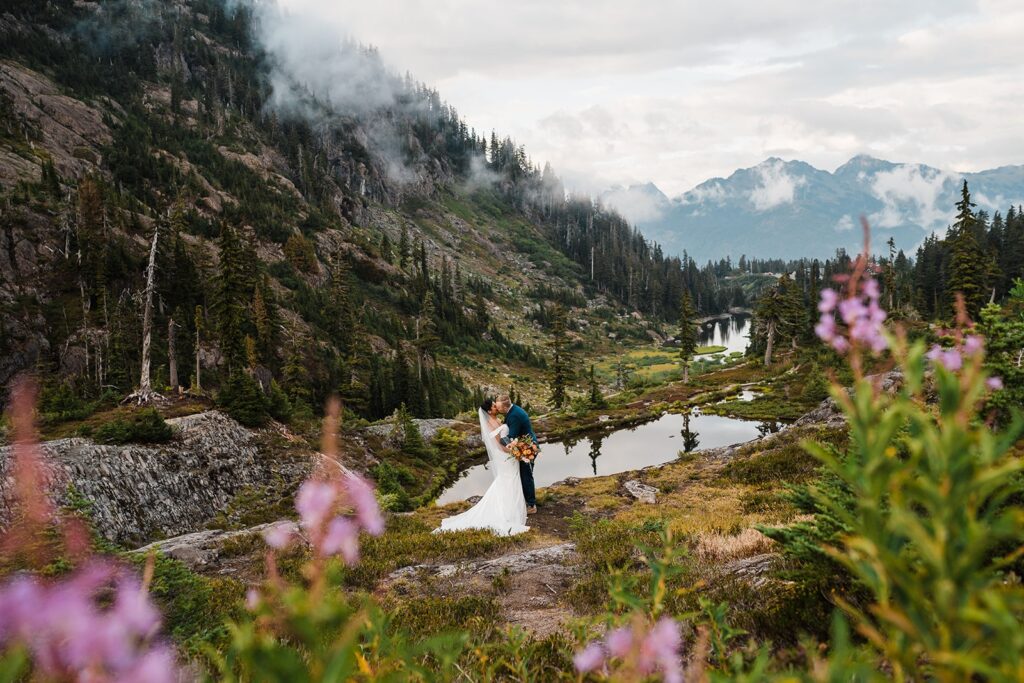 Bride and groom kiss in the North Cascade mountains during their sunset photos