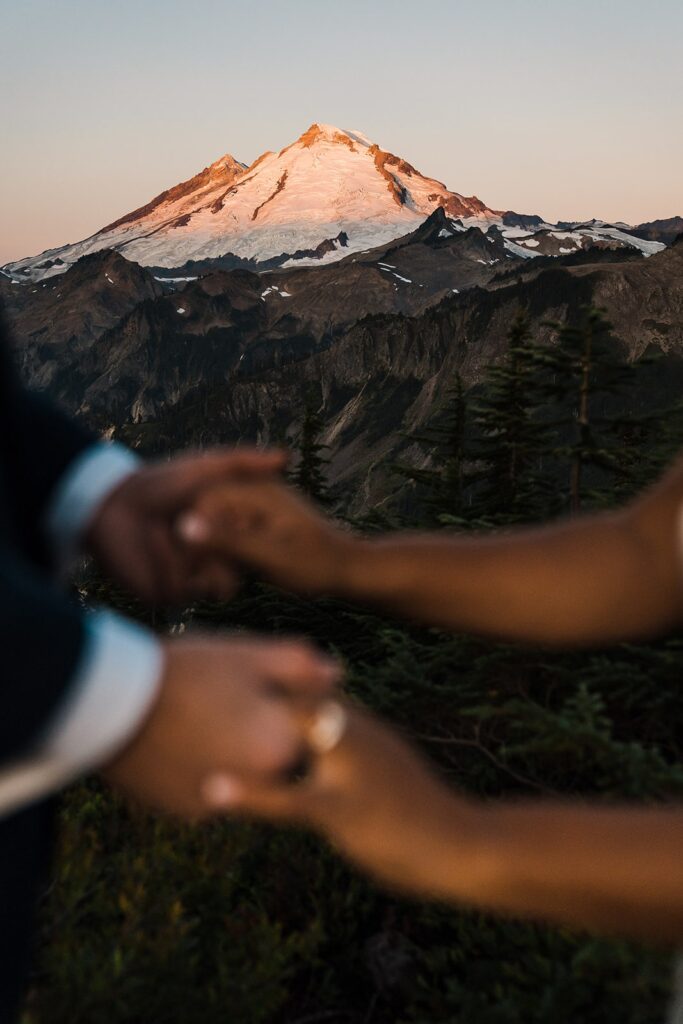 Bride and groom hold hands during their sunset photos in the North Cascades