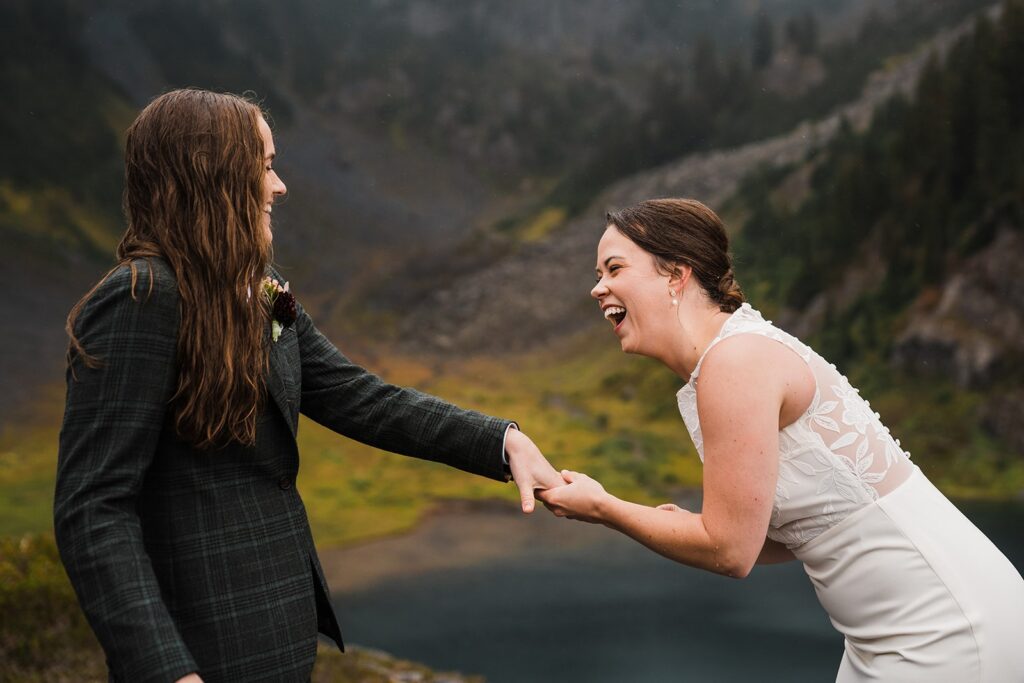 Brides laugh during their North Cascades wedding ceremony in the rain