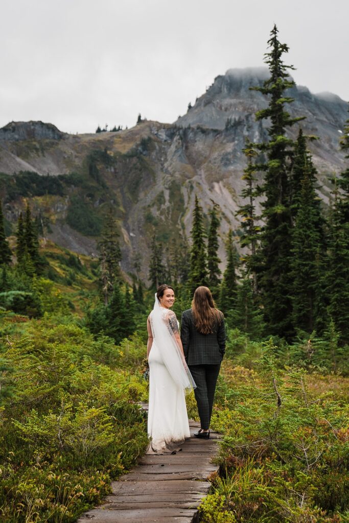 Brides walk through a mountain trail in the North Cascades