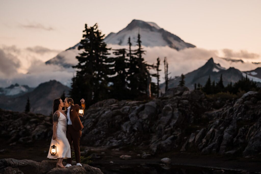 Brides hold lanterns during their wedding couple photos at sunset in the North Cascades