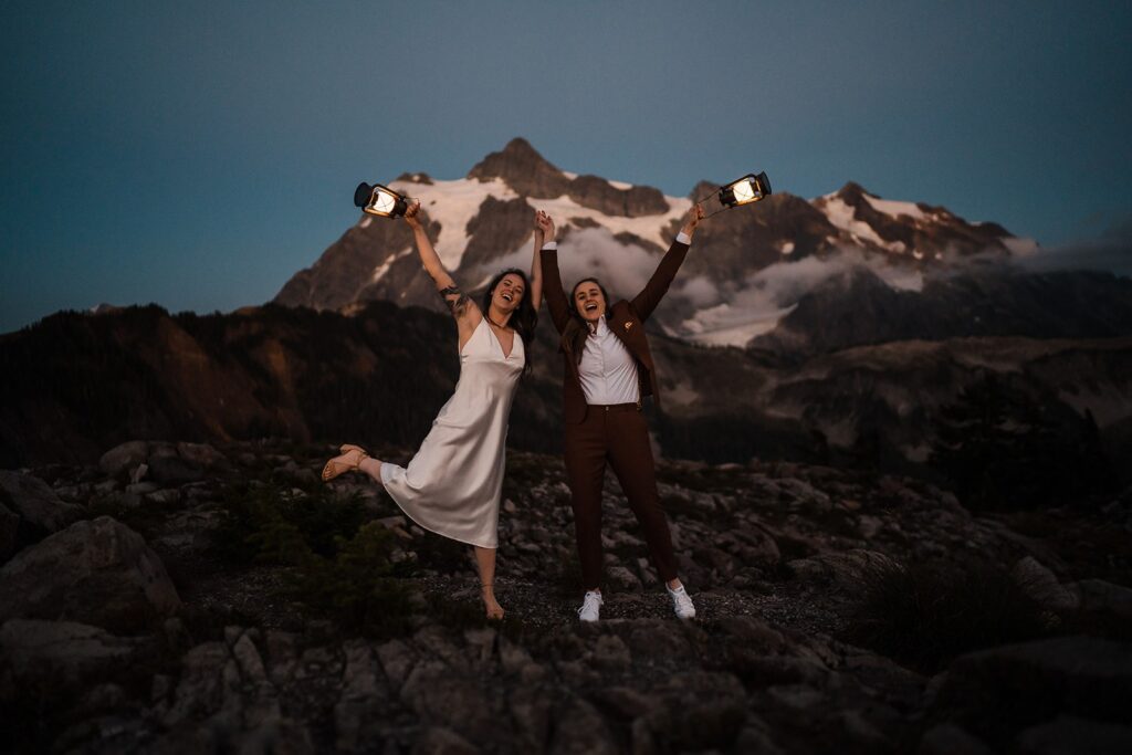 Brides hold lanterns during their wedding couple photos at sunset in the North Cascades