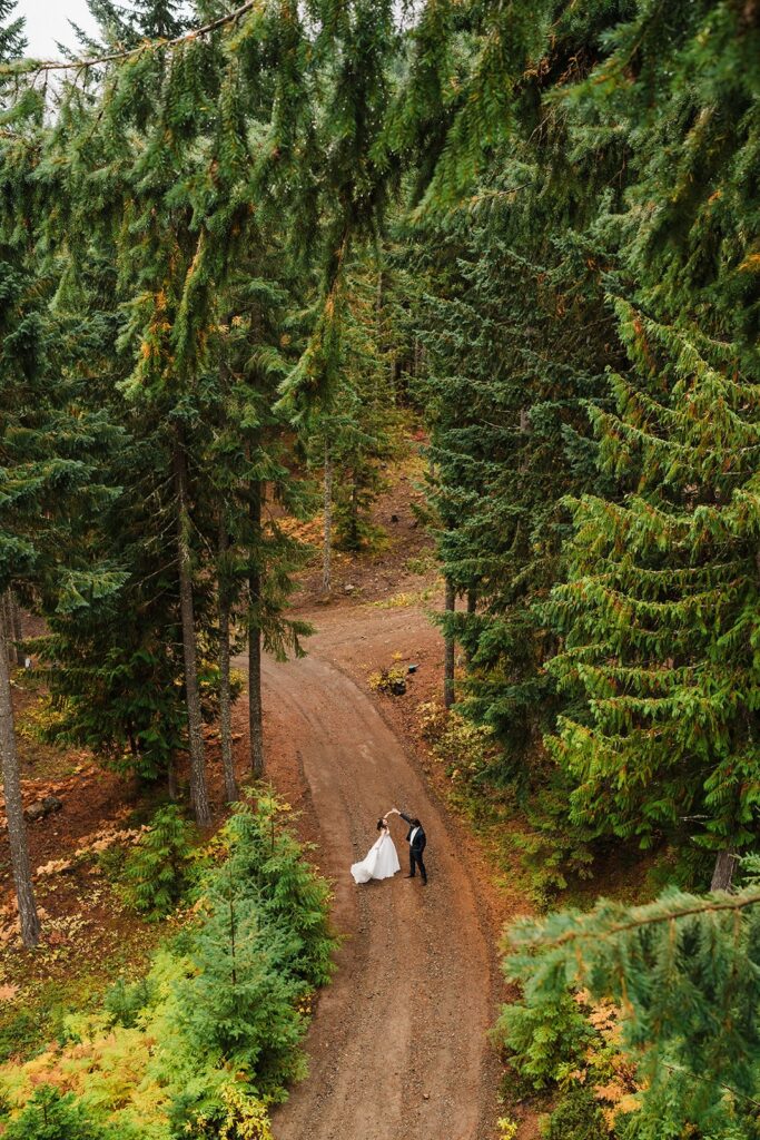 Bride and groom dance on a forest road in Snoqualmie after their wedding first look 