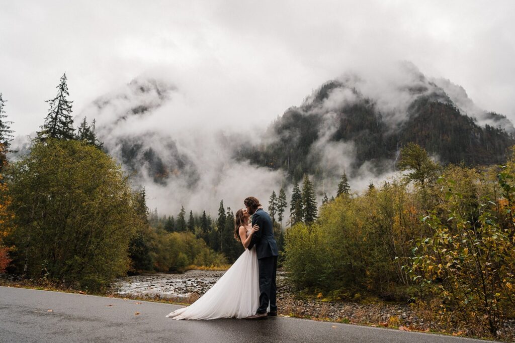Bride and groom kiss during their rainy forest elopement photos in Washington 