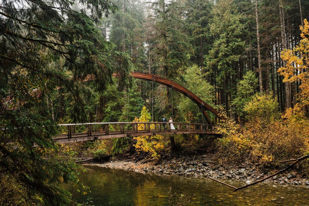 Bride and groom walk across a suspension bridge during their elopement in Snoqualmie