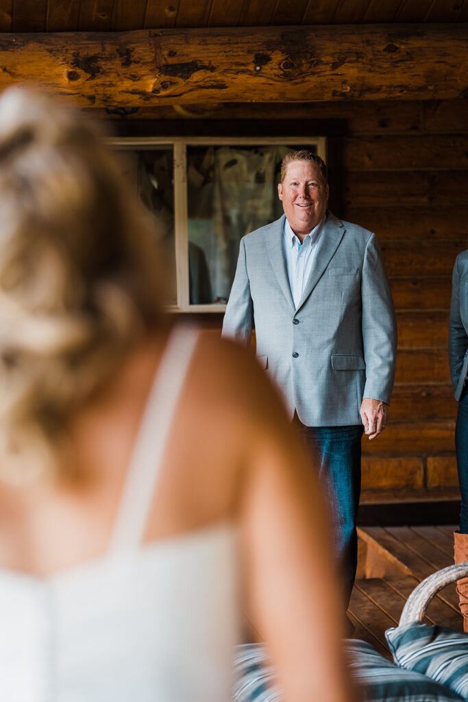 Bride and father first look on the porch of a cabin in Colorado