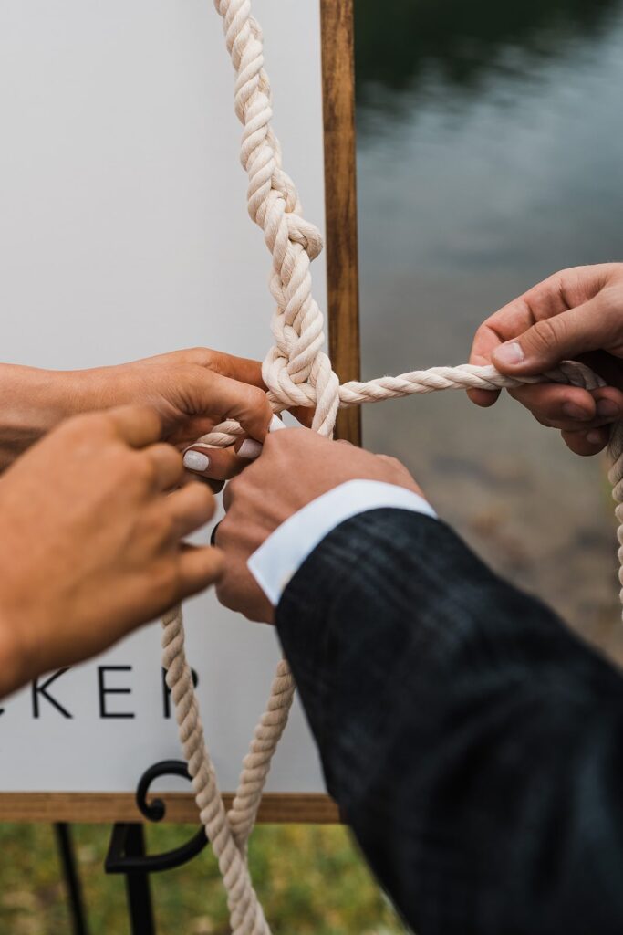 Bride and groom tie a knot with white ropes during their Telluride elopement ceremony
